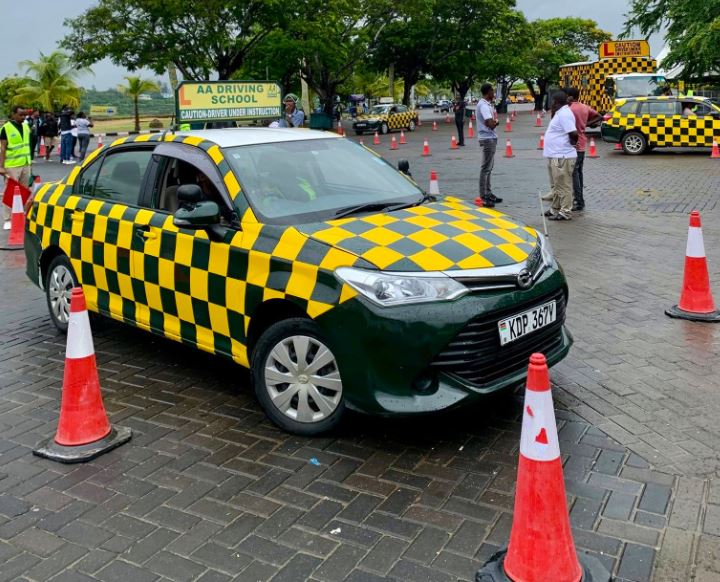 A car parked at a parking with people standing besides