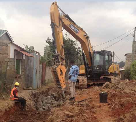 Workers on a site and a SANY excavator breaking roack