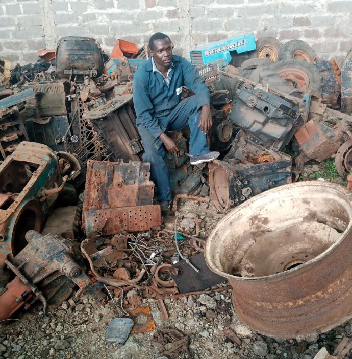 Mechanic at a garage with engines in the background
