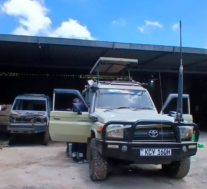 A LANDCRUISER SAFARI VAN WITH OPEN SUNROOF ON A CLEAR SKY
